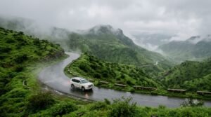 White SUV on a misty mountain road in Dhofar, Oman, during Khareef season.